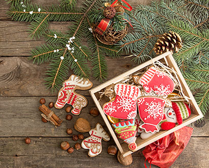 Granris och julfigurer mot en träbakgrund
